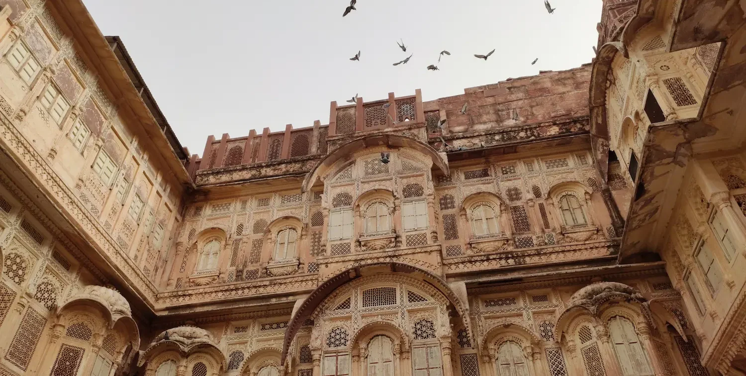 Exterior front view of the grand red sandstone ramparts and intricately carved balconies of Junagarh Fort in Bikaner.